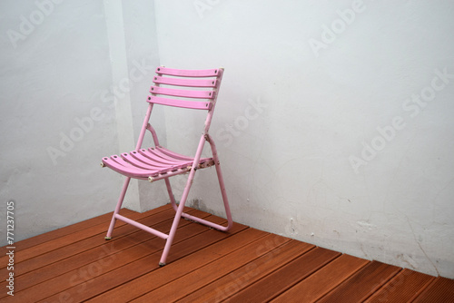 pink chair in the corner of the white wall