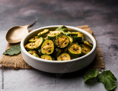 tendli / kundroo sabzi or kovakkai poriyal also known as ivy gourd, served in a bowl or karahi photo