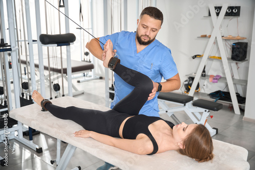 Experienced kinesiologist uses a special simulator to work with patient