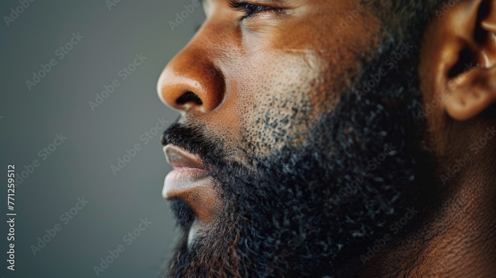 Obraz premium side view profile portrait of a black man with a long full beard on a studio background
