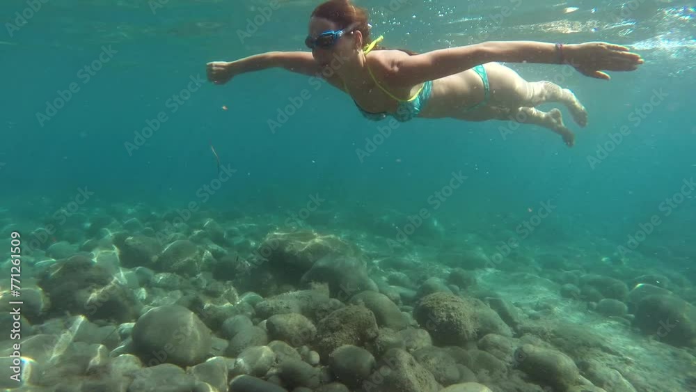Young pretty woman in blue bikini swimming underwater in a sea, beautiful light. . High quality FullHD footage Young pretty woman in blue bikini swimming underwater in a sea, beautiful light. . High quality FullHD footage