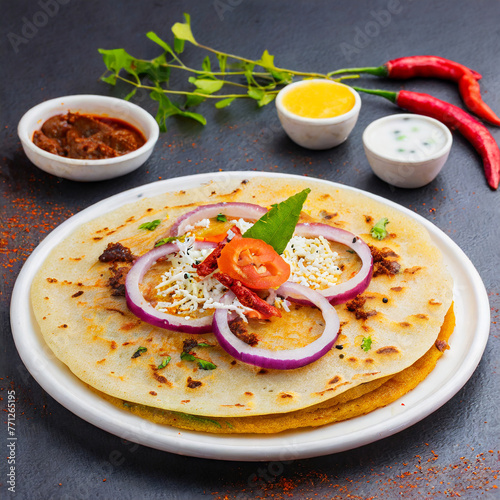 uthappam or uttapam is a type of dosa from south india which is thicker, with tomato, onion and chilli toppings photo