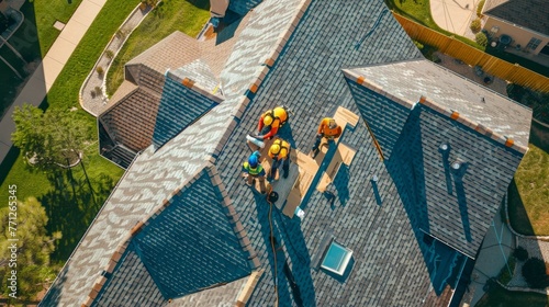 Aerial view of workers on a steep residential roof during sunny day