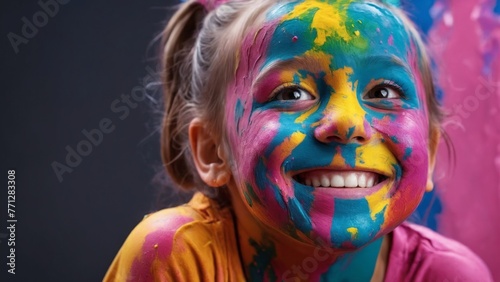 A little girl smeared in multicolored paint a grey background. Children s artistic creativity.