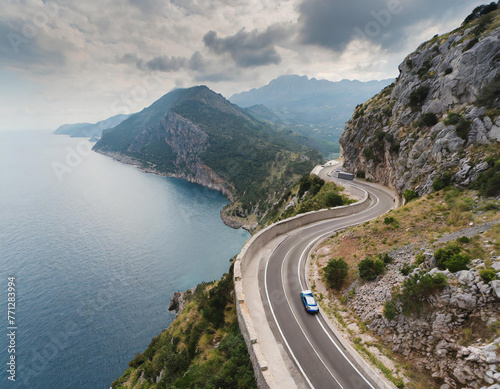 road in the mountains, a car with a scenic route alongside the ocean, a road trip in Europe, top view from above
