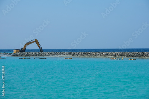 The Excavator digging and expanding the harbour area at the construction area of Ukulhas. Ukulhas, one of the inhabited islands of Alif Alif Atoll.
