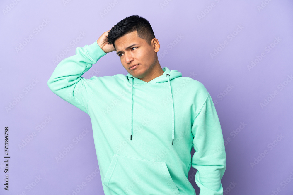 Young Ecuadorian man isolated on purple background having doubts while scratching head Young Ecuadorian man isolated on purple background having doubts while scratching head