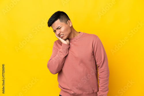 Young Ecuadorian man isolated on yellow background with toothache