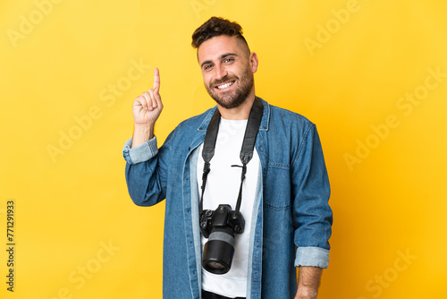 Quadro su tela Photographer man isolated on yellow background pointing up a great idea