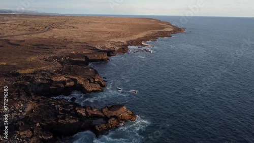 Iceland Drone Shots - 4K. Brimketill lava rock pool, flying over coast, waves crashing on the rocks, showing off the Icelandic landscape and coast. photo