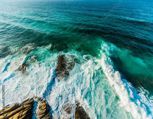 From above aerial view of turquoise ocean water with splashes and foam for abstract natural background and texture