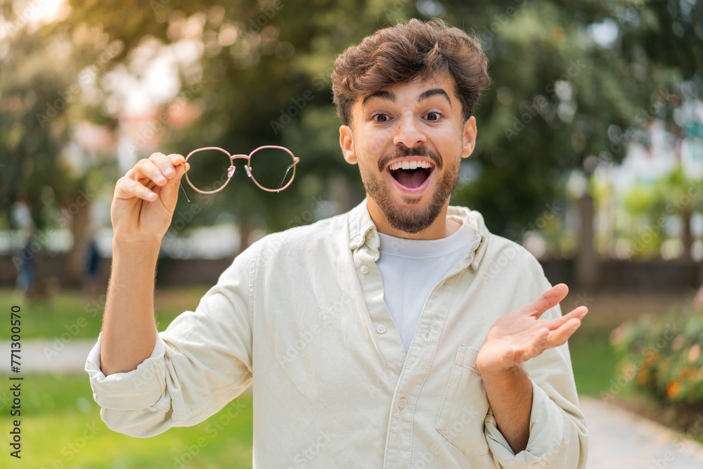© luismolinero - Young Arabian handsome man with glasses at outdoors with shocked facial expression