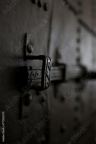 antique metal bolt on an iron door in a gloomy background