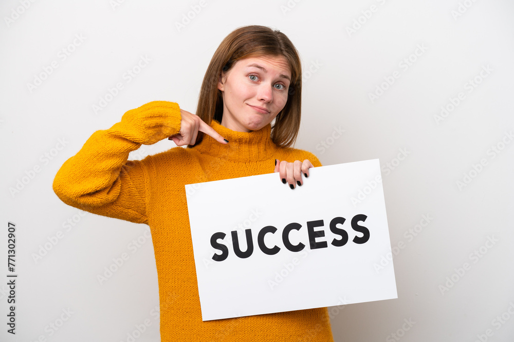 Young English woman isolated on white background holding a placard with text SUCCESS and  pointing it