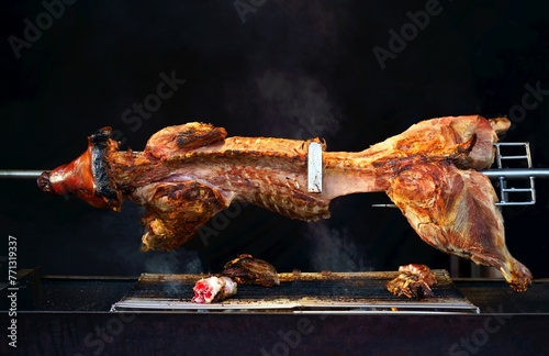 Behang A boar carcass is roasted on a spit