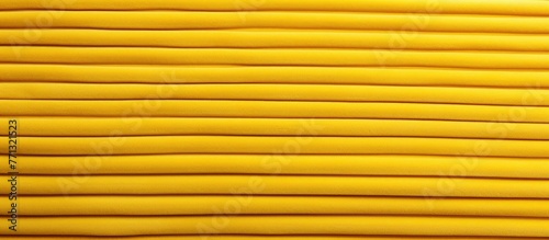 Bright yellow thread neatly wound around a spool in a close-up view  ideal for sewing and crafting projects