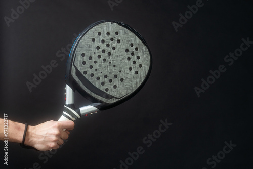 Man ready for paddle tennis serve in studio shot 