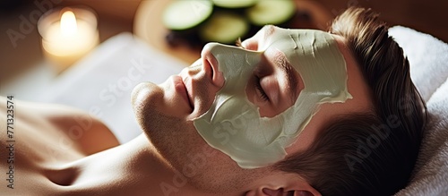 Man wearing a facial mask is lying down and enjoying a rejuvenating skincare treatment at a spa salon in a tranquil setting