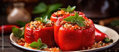 A plate holds three red peppers filled with couscous, garnished with a sprig of fresh basil