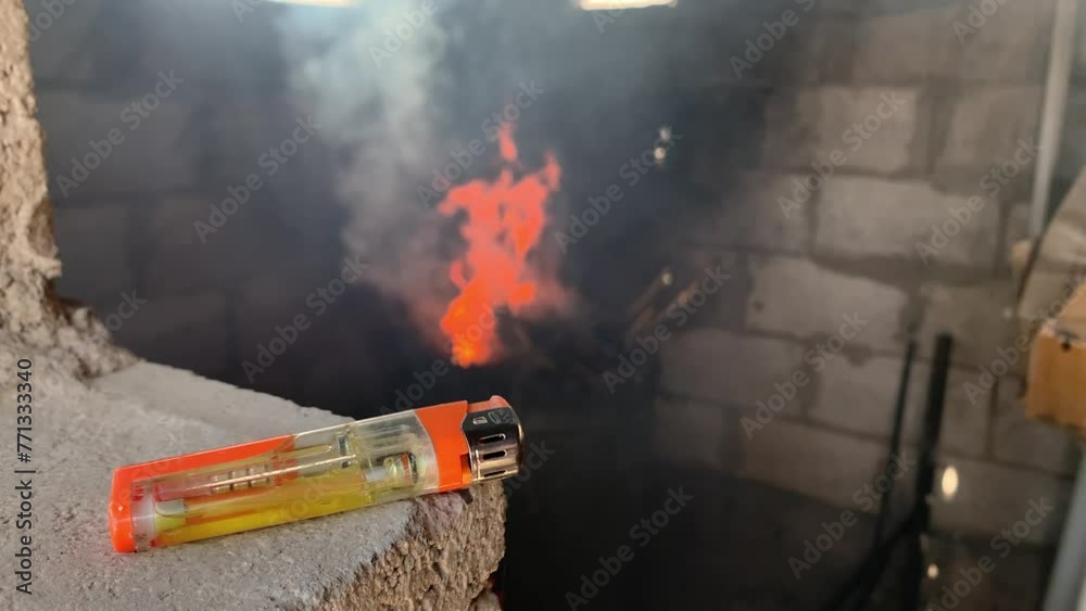 A gas lighter with a burning flame in the stove in the background A gas lighter with a burning flame in the stove in the background
