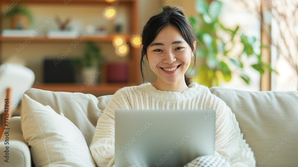Smiling woman in casual clothing using a laptop at home, evoking a sense of comfort and modern remote working lifestyle. Smiling woman in casual clothing using a laptop at home, evoking a sense of comfort and modern remote working lifestyle.