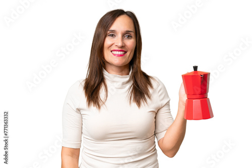 Middle-aged caucasian woman holding coffee pot over isolated background smiling a lot