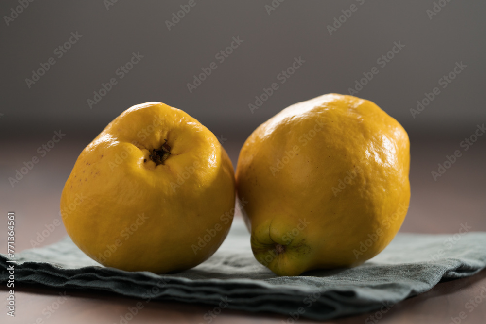 Two ripe quince fruit on wood table
