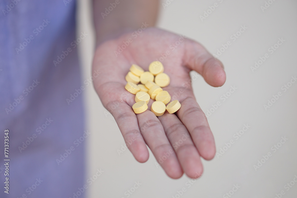 Selective focus on some yellow pain killer medicine pills on hands. Concept, Health care, treatment, remedy illness and self therapy at home. Taking overdose pills. Selective focus on some yellow pain killer medicine pills on hands. Concept, Health care, treatment, remedy illness and self therapy at home. Taking overdose pills.