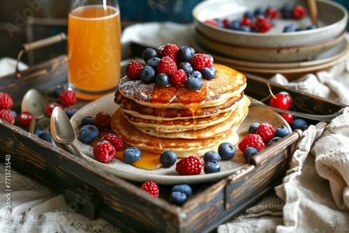 Delicious Homemade Pancakes with Fresh Berries and Honey on Rustic Wooden Tray with Orange Juice