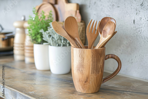 wooden utensils are in a wooden mug sitting on a counte 41d49470-b5a3-4866-9126-c9eca5c6c8f5 photo