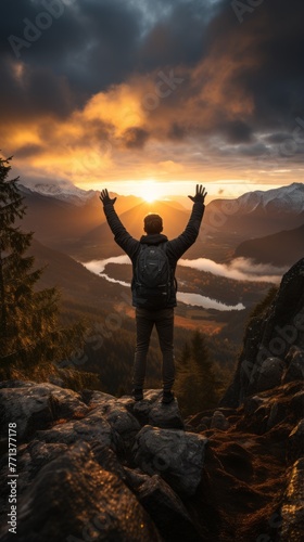 man standing on a mountaintop with his arms raised in the air © Adobe Contributor