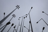 Lampposts in the city against cloudy sky