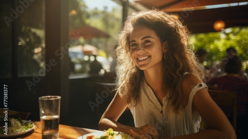 Portrait of a smiling young woman sitting at a restaurant table