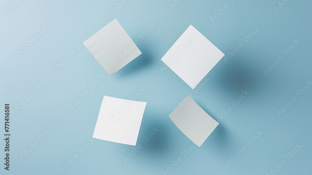 Four white square papers floating above a blue background. Four white square papers floating above a blue background.