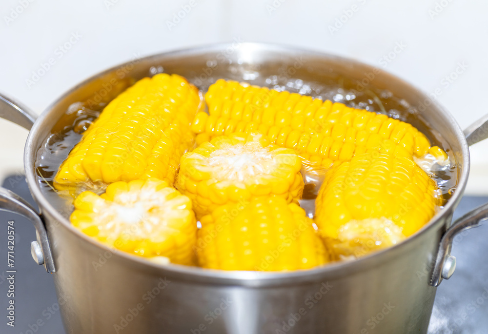 Boiling boiled corn in a pot on the stove in the kitchen
