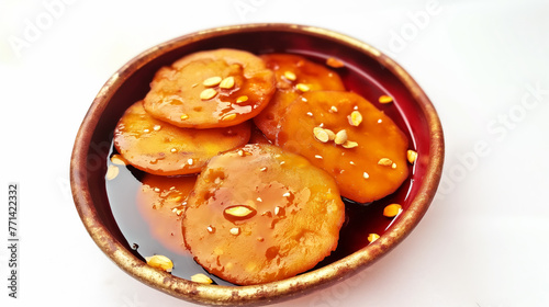 Malpua, traditional Indian sweet pancakes served with Rabri, garnished with almond flakes and rose buds, on a white background photo