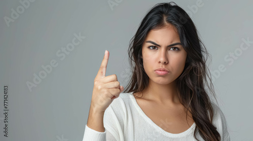 Angry Latin Woman Making A Disapproving Gesture With Her Finger. Conveying a Sense of Disagreement or Refusal