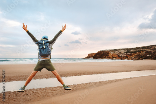 Man with backpack jumping on the beach tourist traveling in Greece healthy lifestyle happy emotions success concept adventure active summer vacations outdoor © EVERST