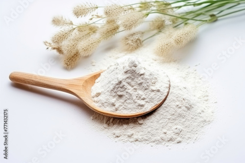 A wooden spoon overflowing with white flour on a clean surface, accompanied by soft, delicate grass flowers in the background, evoking a sense of baking and freshness.