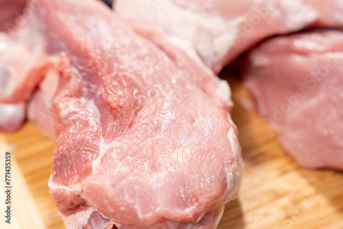 Pork meat cut into pieces lies on a cutting board. Pork meat close-up.