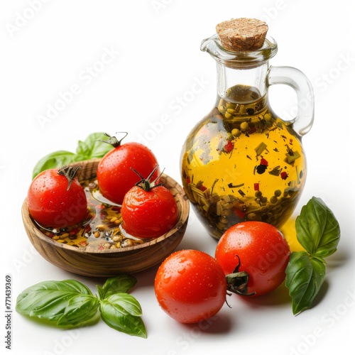 Vibrant fresh tomatoes paired with a glass bottle of herbed olive oil and fresh basil leaves against a white background.