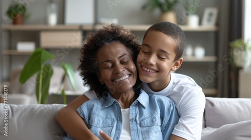 Joyful African American grandmother and grandson hugging, love and family concept