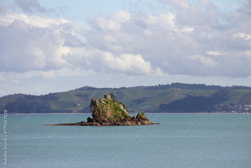 A little rock island on the horizon of Waiheke Island, Auckland, New Zealand