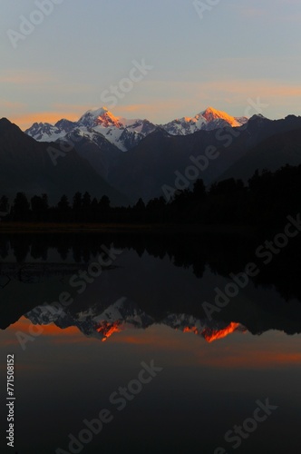 Majestic sunset at Lake Matheson with a reflection of Mount Cook and Mount Tasman, New Zealand. photo