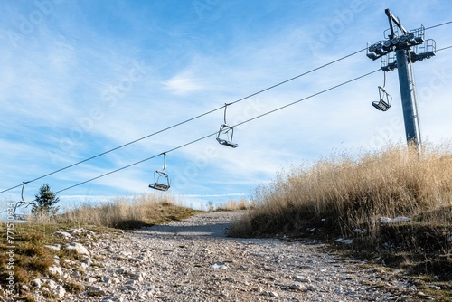 Empty ski lift above a rocky hillside landscape photo