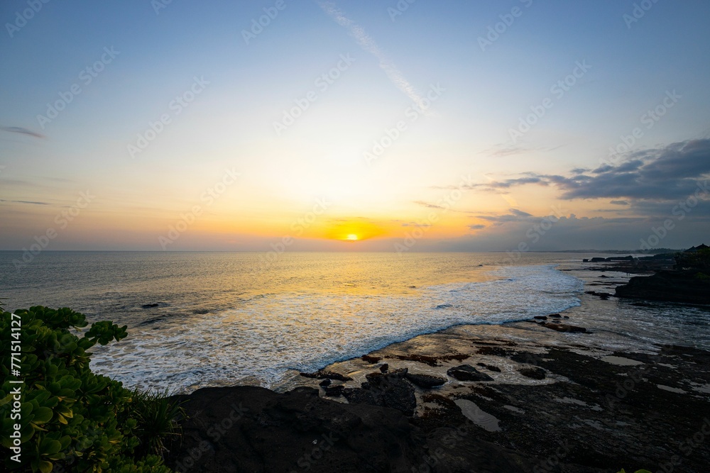 Tranquil beach landscape featuring a picturesque sunset over the horizon