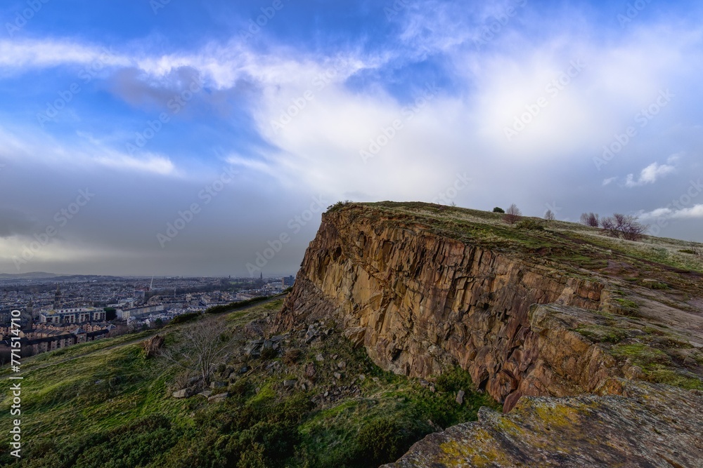 Arthur's Seat hill in Scotland, Edinburgh looking over a sprawling cityscape on a cloudy day