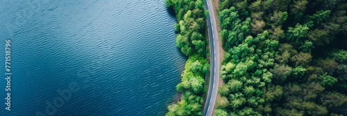 A birds eye view of a road winding next to a body of water, showcasing the scenic route along the waters edge © pham