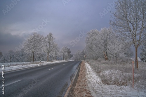 a road on a hill side covered in snow under grey skies
