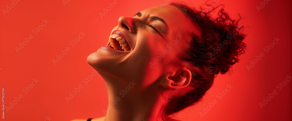 Studio portrait of woman yelling, intense red background and lighting Studio portrait of woman yelling, intense red background and lighting